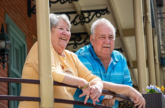 A man holds up a wooden planter of flowers