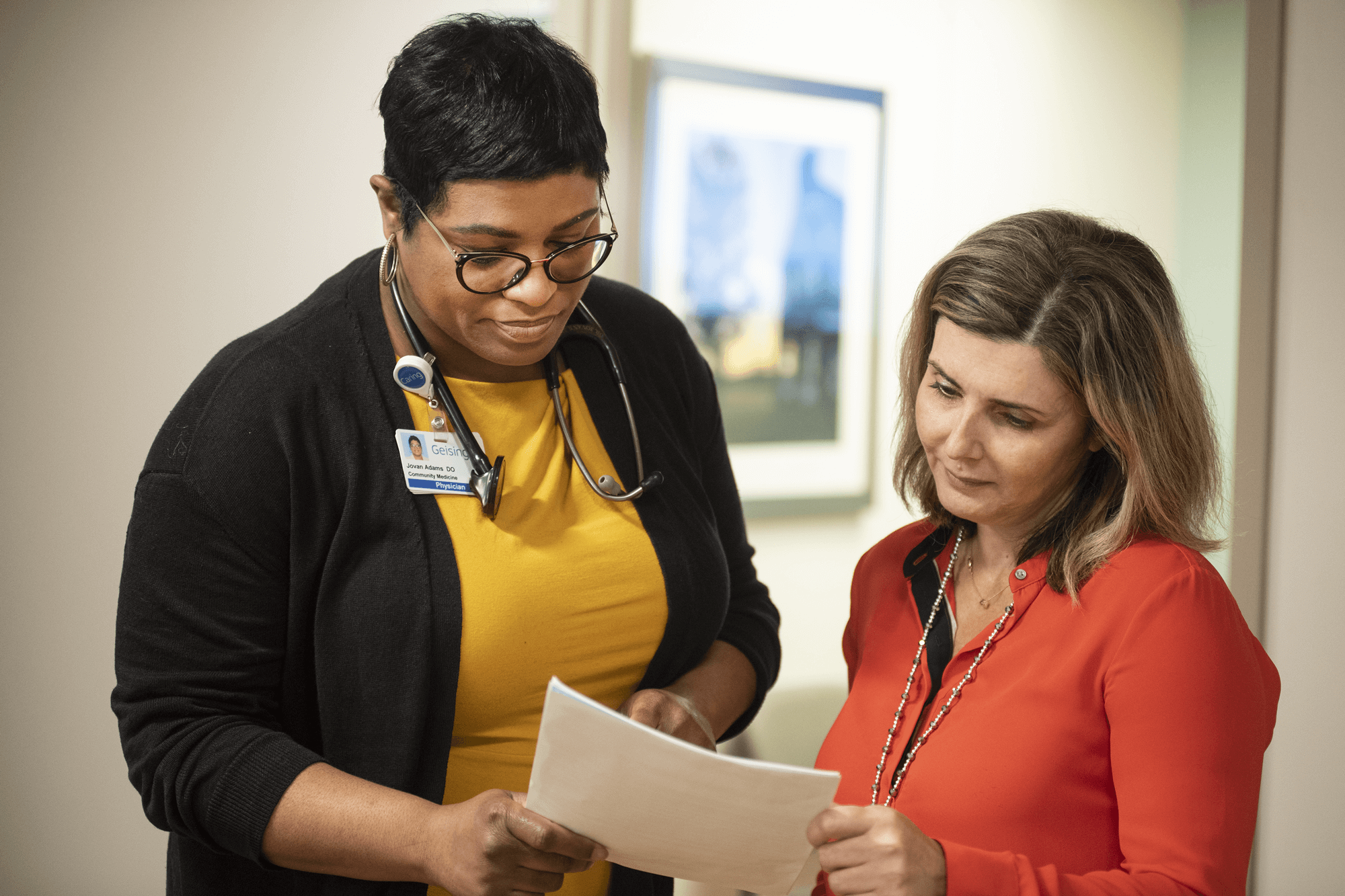 Two employees discuss results on a sheet of paper