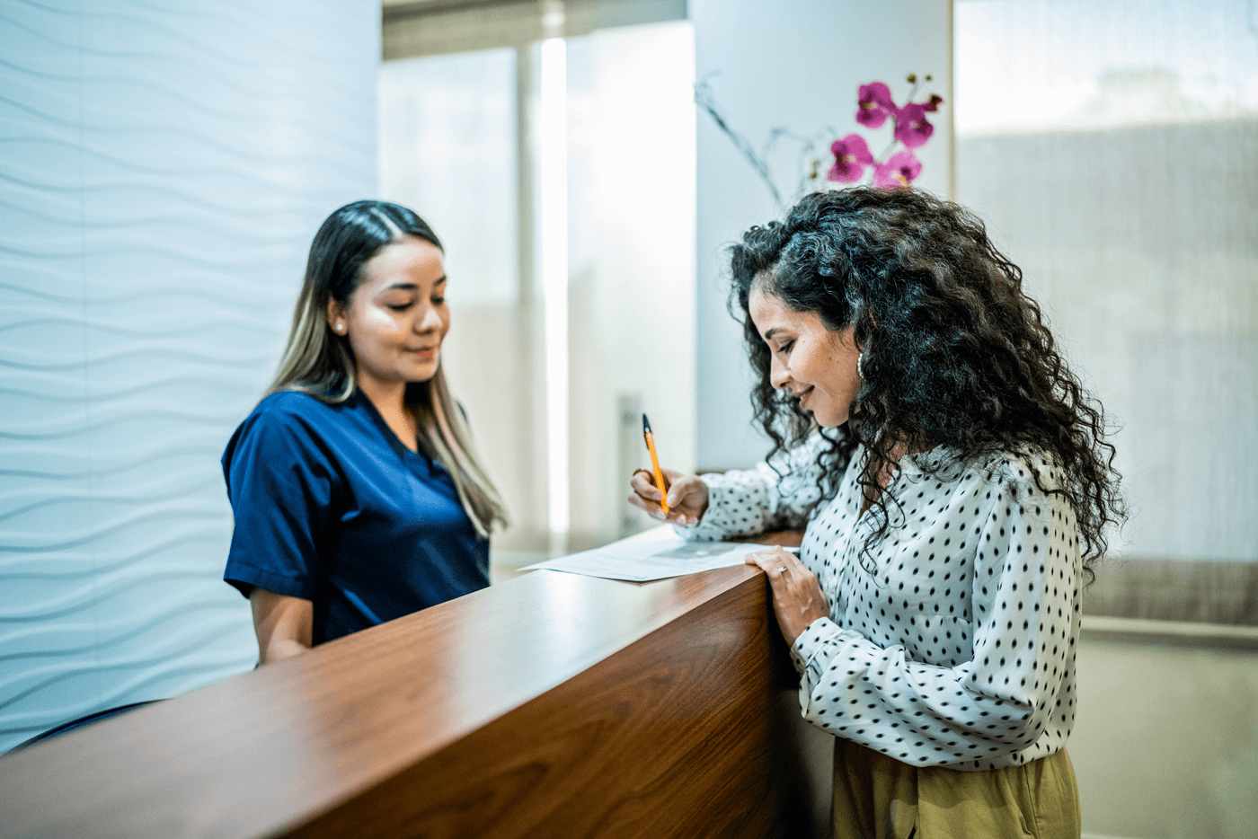 A woman signs paperwork at a health office