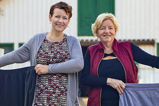 Two women holding pants that no longer fit as they had bariatric surgery