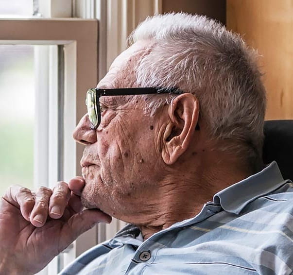 A senior man looking out the window