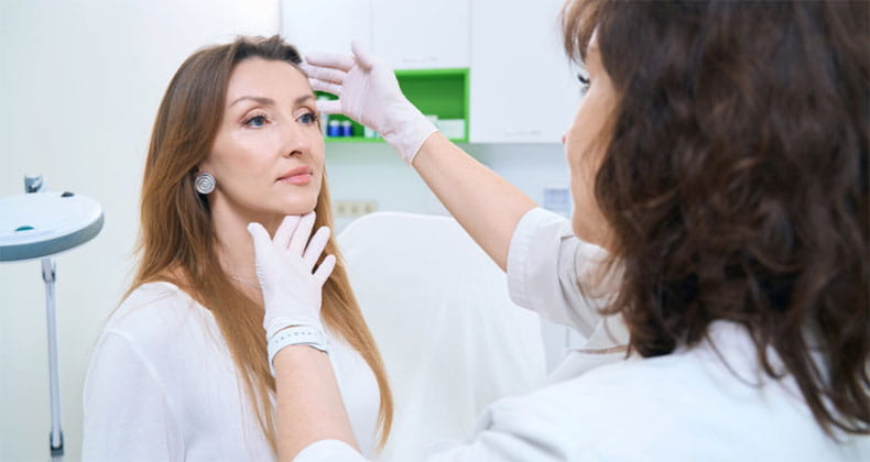 A dermatologist checking a patients face