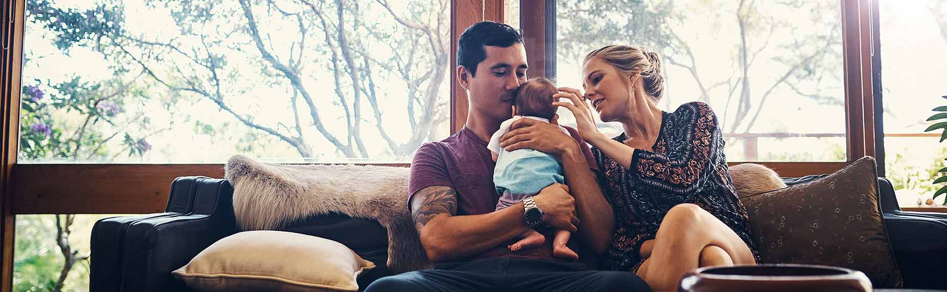 Young parents bonding with their newborn baby boy at home
