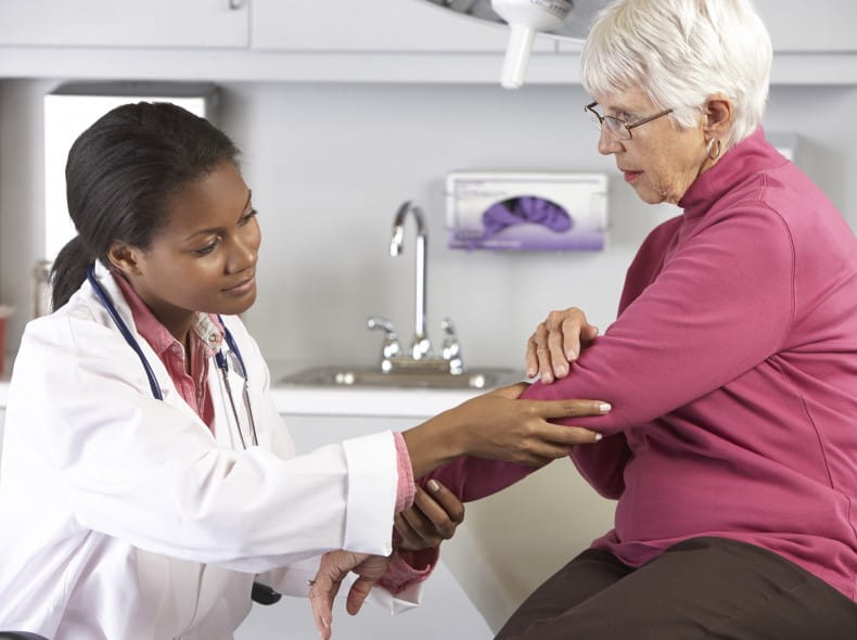 an image of a doctor looking at a older patients elbow
