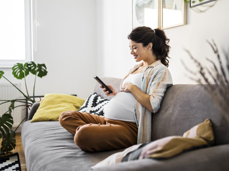 a pregnant woman looking at her phone