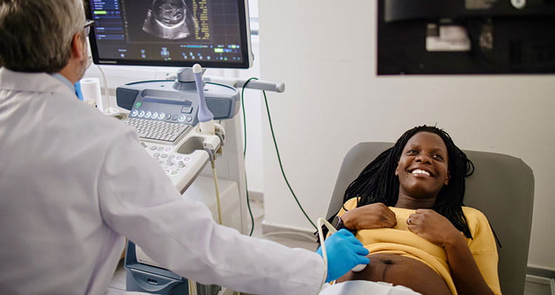 a pregnant woman receiving a ultrasound at a doctors office