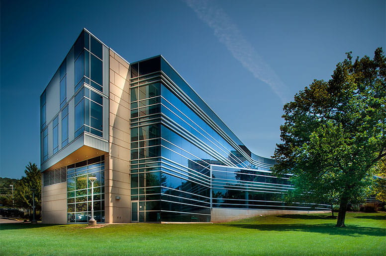 Modern medical education and healthcare facility with glass architecture and landscaped campus grounds.