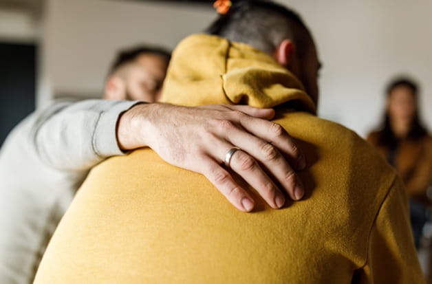 Men in a group therapy session for substance use disorder treatment.
