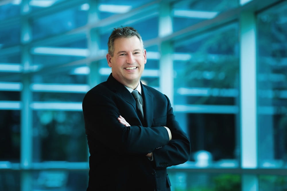 Dr. Ryu smiling in front of building