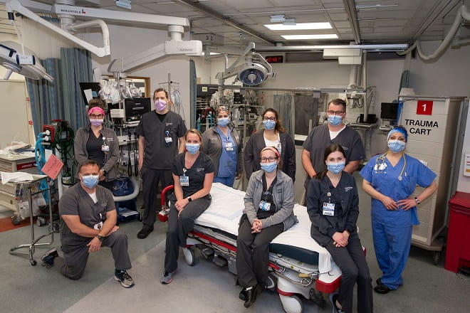 Geisinger nurses posing around a surgical bed in one of many hospital locations