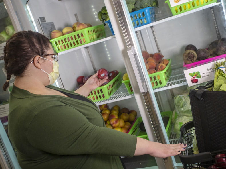 a woman shopping for food at the Fresh Food Farmacy