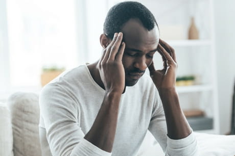 Man holding head with hands