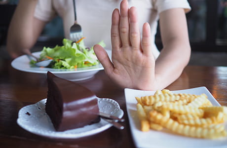 Cake and fries being pushed away.