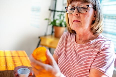 A woman reading a prescription label