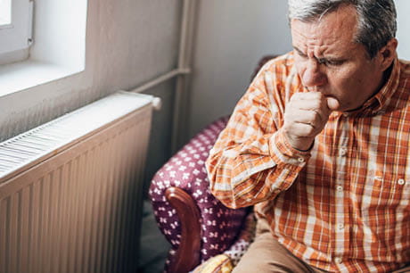 An older man coughing