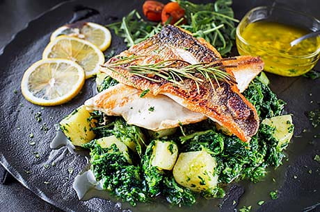 A prepared meal of braised cod with wild ramps.