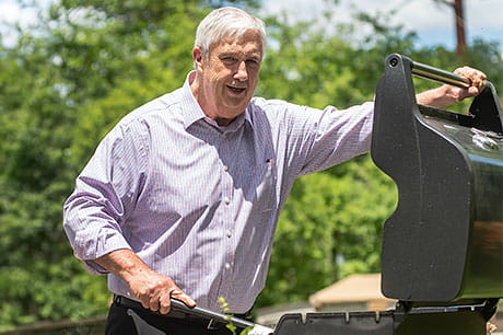 A man is preparing to grill outside.