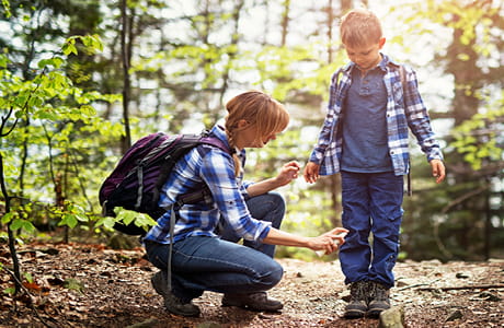 Woman spraying insect repellent on child.
