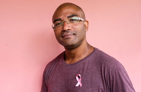 A man wearing a breast cancer ribbon. 