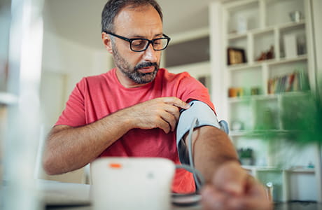 A man taking his blood pressure at home