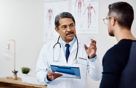 Male doctor consulting a patient  inside a hospital.