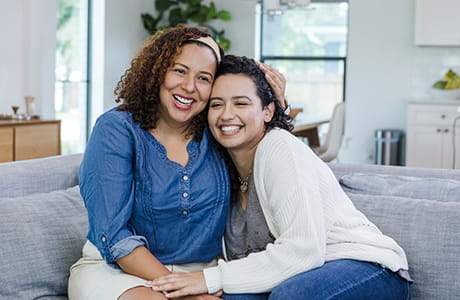 Daughter receiving a hug from her mother.