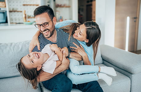 A family laughing on the couch.