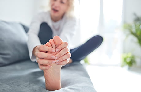 A woman rubbing her dry feet.