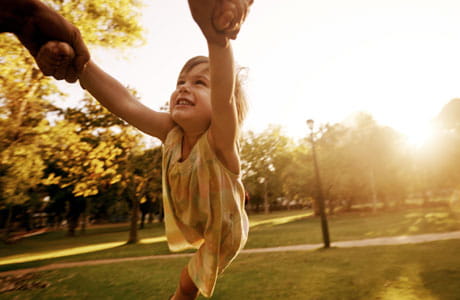 Little girl being swung around at a park.  