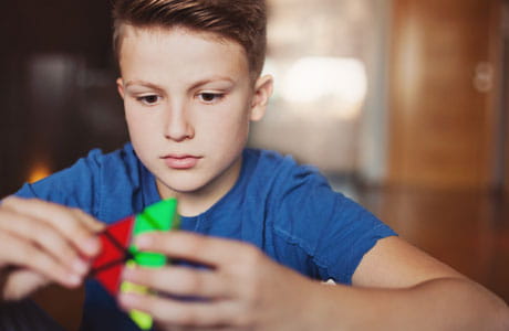 Young boy playing a hand held game.