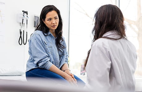 a woman talking to her doctor in a medical office