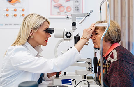 A woman doctor checking  a woman patients eyes for  for glaucoma