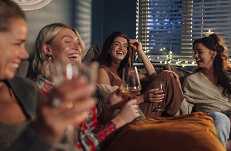 a group of woman drinking wine and socializing