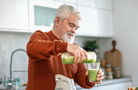Man in kitchen enjoying a healthy smoothie
