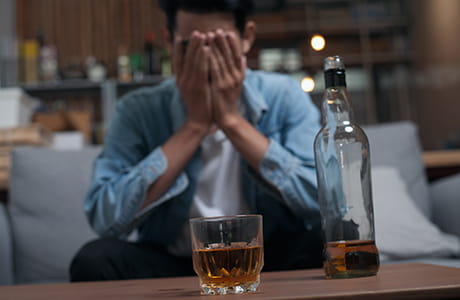 An adult man drinking alone 