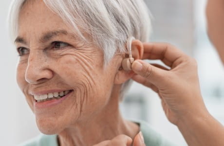 Elderly woman getting fitted for a hearing aid