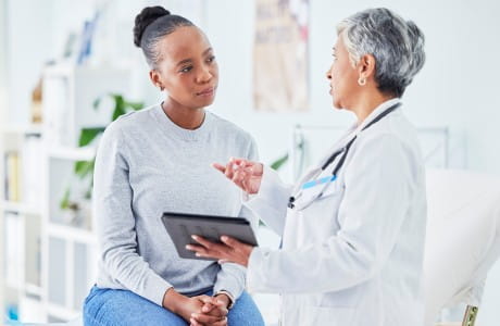 Female doctor talks to female patient about abnormal mammogram