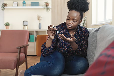 Person checking blood glucose levels with a glucose meter, illustrating routine diabetes monitoring and self-care.