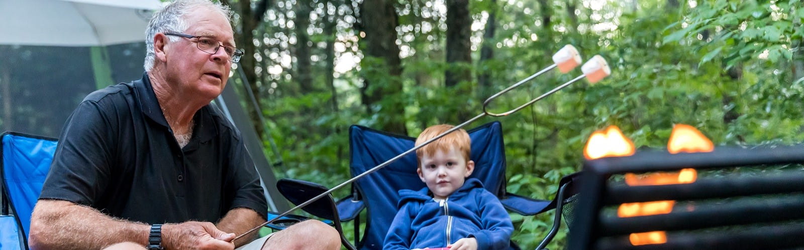 A man and his grandson toasting marshmallows