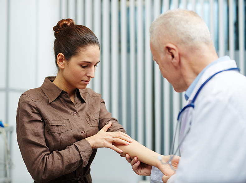 A doctor examining a woman with skin cancer and considering Mohs surgery
