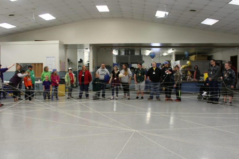 Camp Courage campers play a game with string