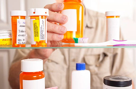 An open medicine cabinet with several prescription bottles.