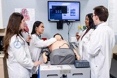 Medical students participating in a clinical simulation training exercise in a healthcare education setting.