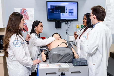 Medical students participating in a clinical simulation training exercise in a healthcare education setting.