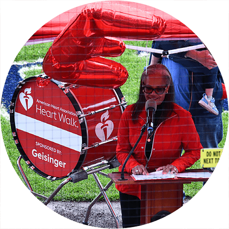 Speaker addressing participants at an American Heart Association Heart Walk event sponsored by Geisinger.