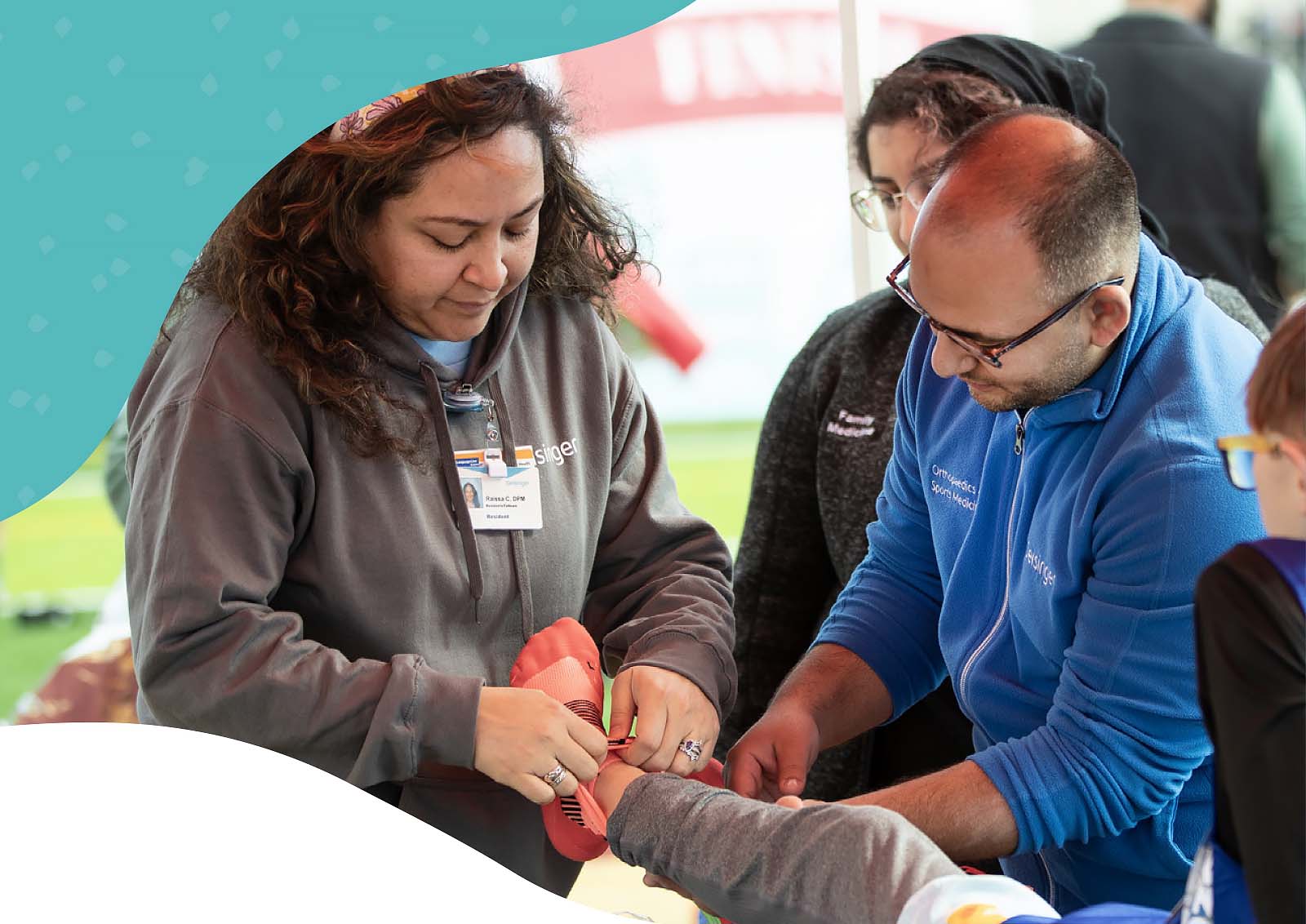 Healthcare professionals demonstrating sports medicine and injury prevention techniques during a community event.