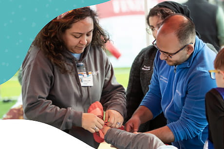 Healthcare professionals demonstrating sports medicine and injury prevention techniques during a community event.