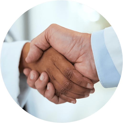 A closeup photograph of two medical providers shaking hands.