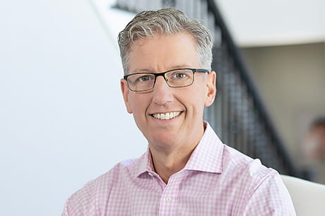 Professional headshot of a healthcare leader wearing glasses, representing patient care leadership and recovery support services.