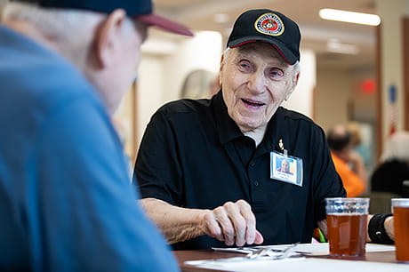 Two elderly men talking at a local event for seniors.